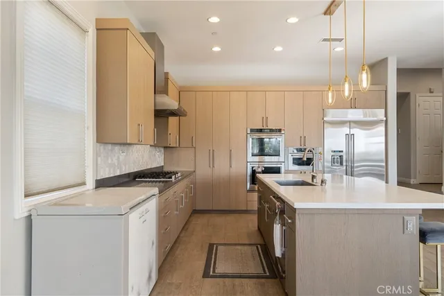 a kitchen with stainless steel appliances granite countertop a sink a stove and a refrigerator