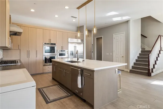 a kitchen that has a lot of cabinets in it and wooden floors