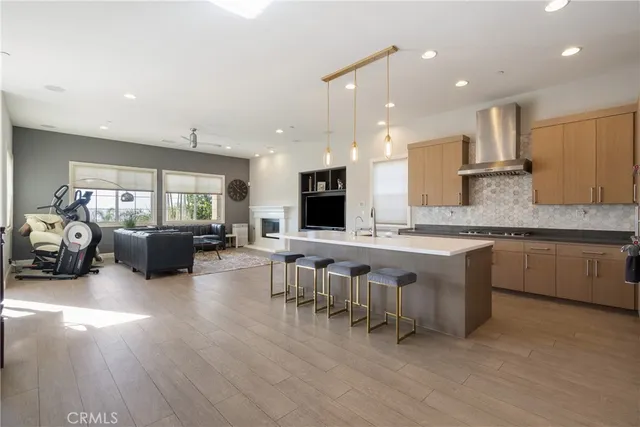 a large white kitchen with lots of counter space and chandelier