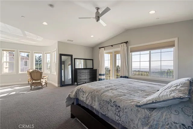 a spacious bedroom with a bed a couch and large window with outer view