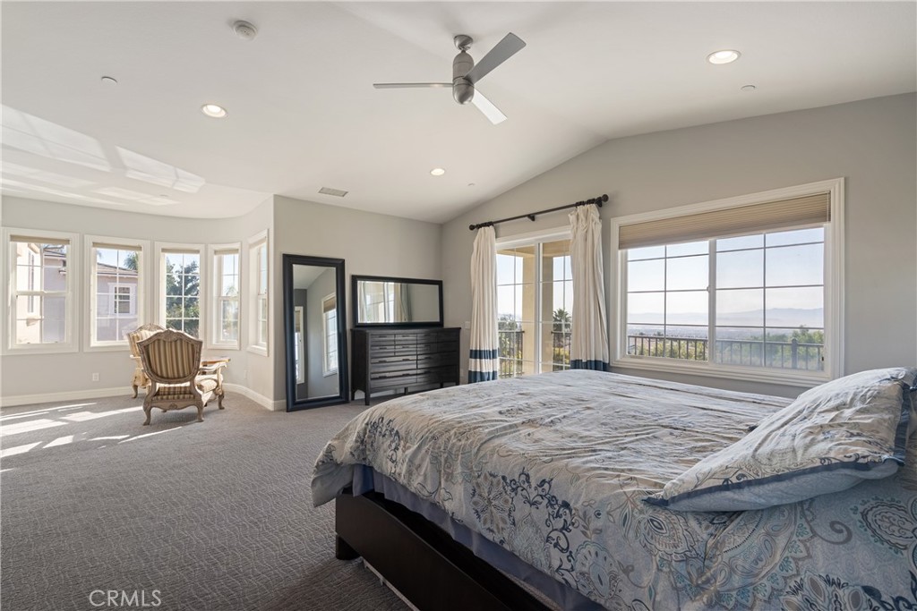 9669 Norbrook Drive Rancho Cucamonga, CA 91737 - Photo 25 of 47 a spacious bedroom with a bed a couch and large window with outer view