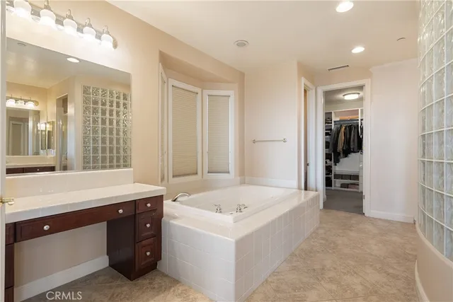 a spacious bathroom with a tub sink and mirror