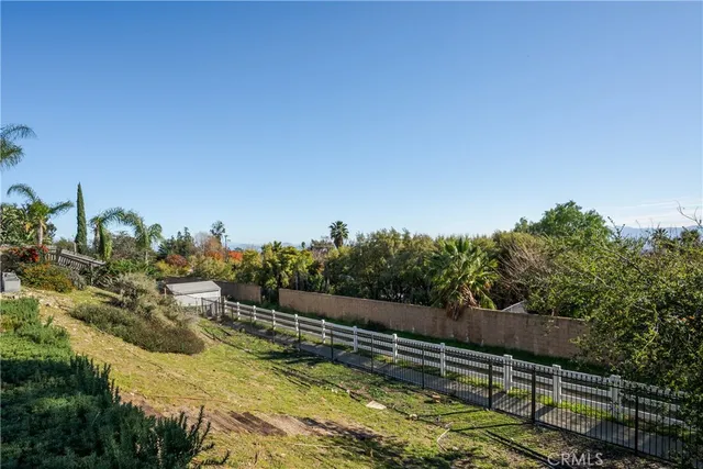 a view of a yard with wooden fence