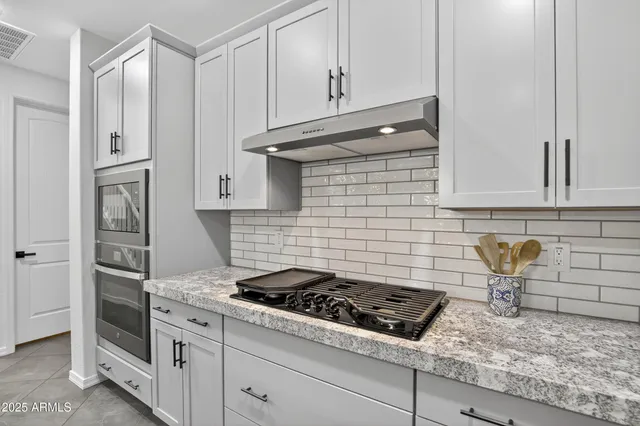 a kitchen with granite countertop a stove and a sink