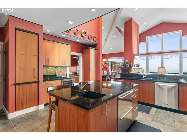a kitchen with stainless steel appliances granite countertop a sink a stove and a refrigerator