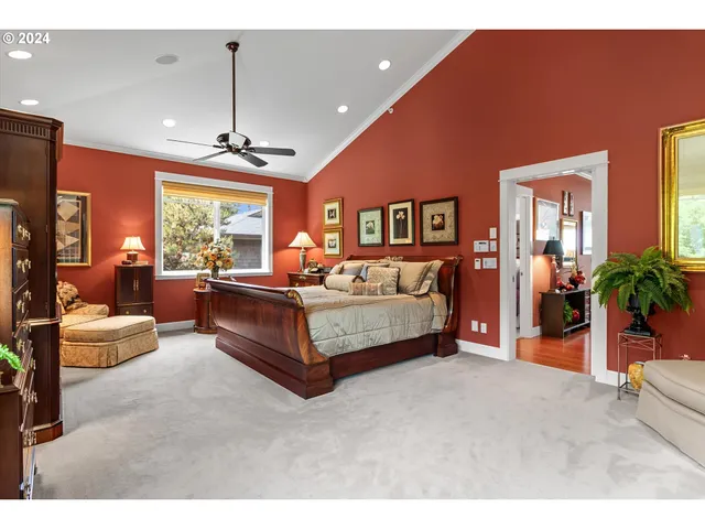 a bedroom with a bed dresser flowerpot and window