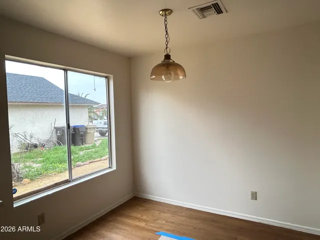 a room with wooden floor and windows