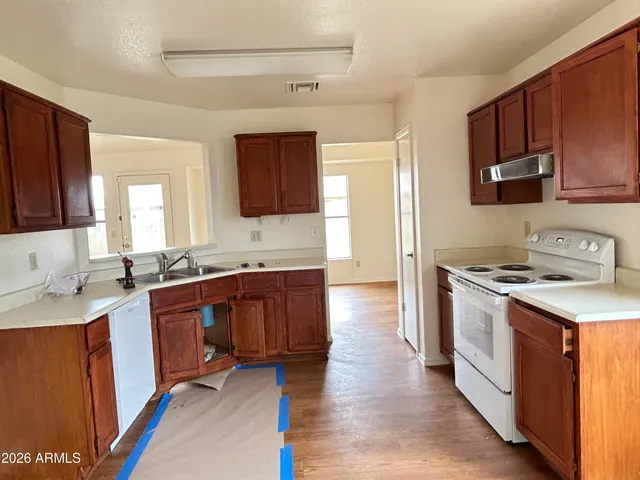 a kitchen with stainless steel appliances granite countertop a stove a sink dishwasher and a refrigerator