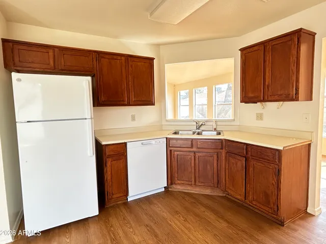 a kitchen with sink a refrigerator and wooden cabinets