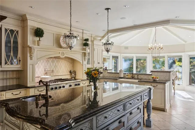 a kitchen with stainless steel appliances granite countertop a sink a stove and a table