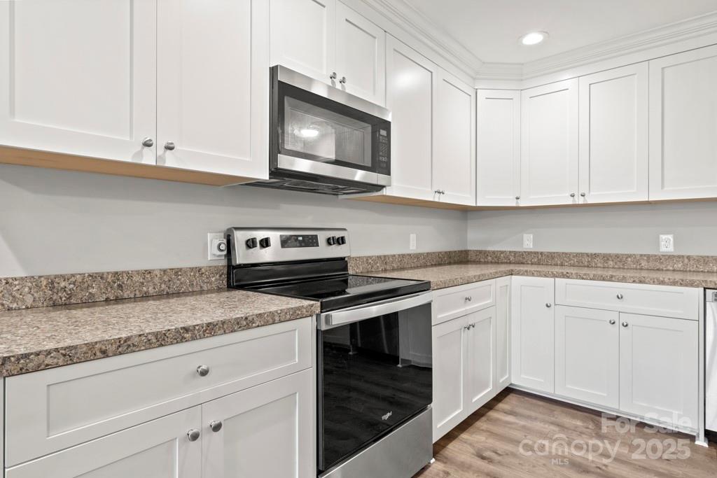 4268 Fletcher Funderburk Road Lancaster, SC 29720 - Photo 10 of 26 a kitchen with granite countertop white cabinets and a stove top oven