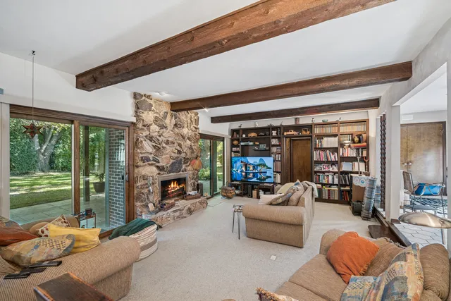 a living room with fireplace furniture and a large window