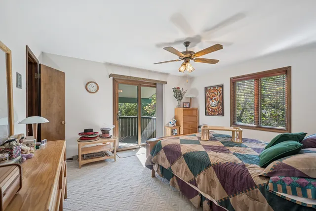 a spacious bedroom with a bed a couch and a chandelier