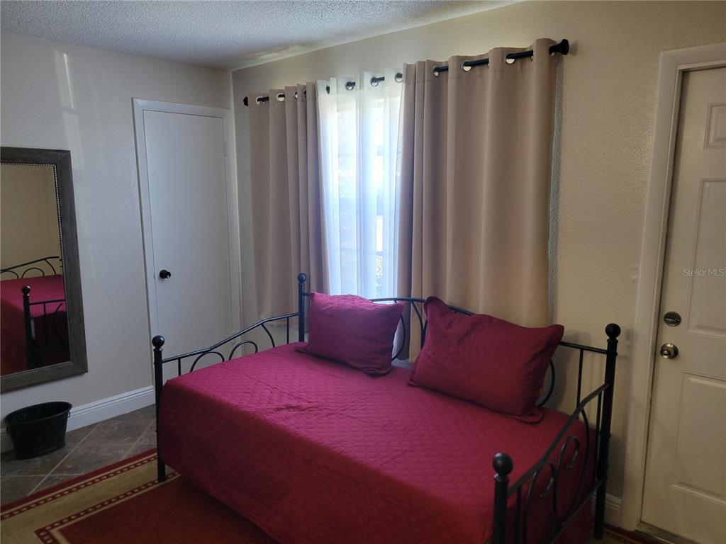 10038 62nd Avenue North, Unit 11 St. Petersburg, FL 33708 - Photo 29 of 43 a bedroom with a bed a window and a mirror