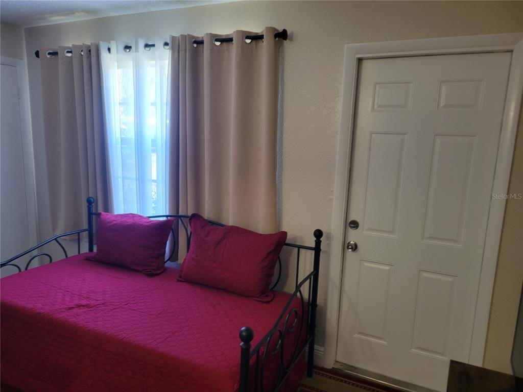 10038 62nd Avenue North, Unit 11 St. Petersburg, FL 33708 - Photo 30 of 43 a bedroom with a bed a window and curtain