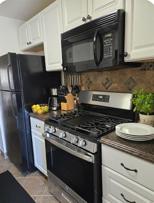 10038 62nd Avenue North, Unit 11 St. Petersburg, FL 33708 - Photo 3 of 43 a kitchen with stainless steel appliances granite countertop a stove a microwave and cabinets