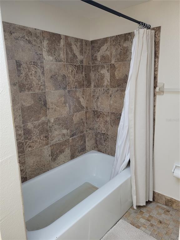 10038 62nd Avenue North, Unit 11 St. Petersburg, FL 33708 - Photo 9 of 43 a bathroom with a bathtub and a shower