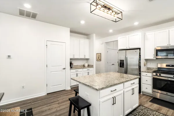 a kitchen with a sink stainless steel appliances and white cabinets