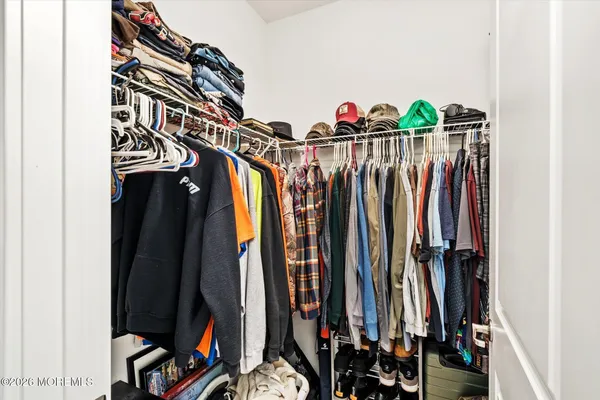 a view of walk in closet with clothes