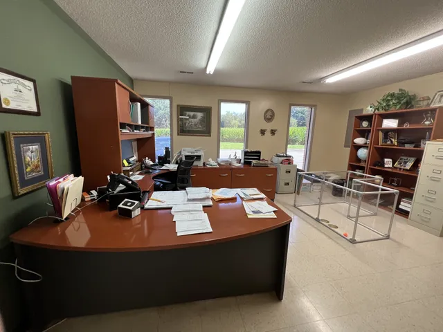 a living room with furniture a bookshelf and a window
