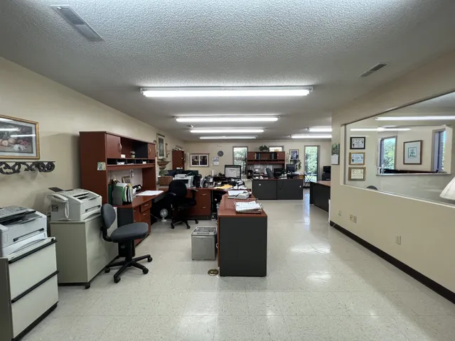 a living room with furniture kitchen view and a window