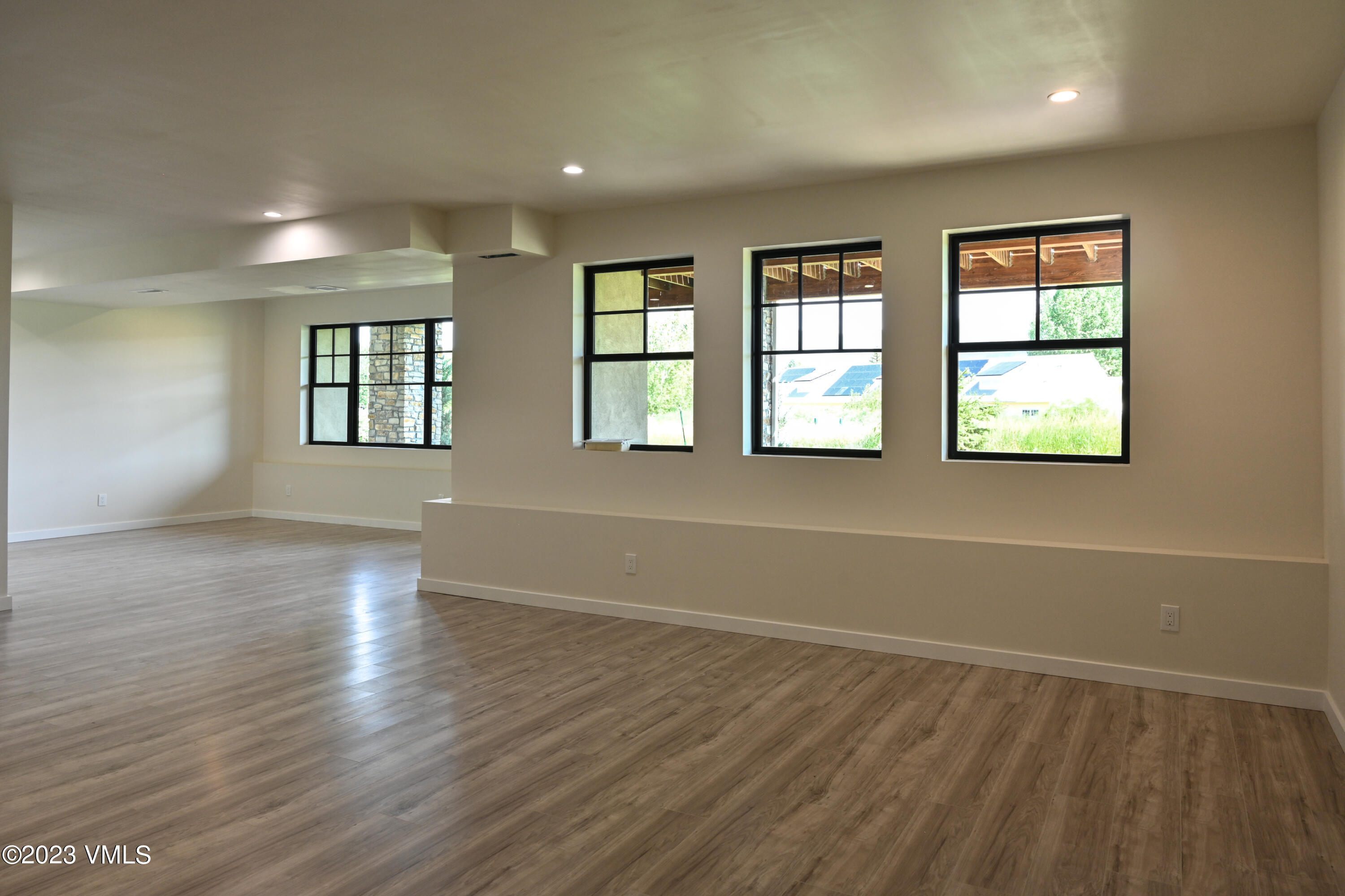 207 Aidan Road Eagle, CO 81631 - Photo 12 of 26 an empty room with wooden floor and windows