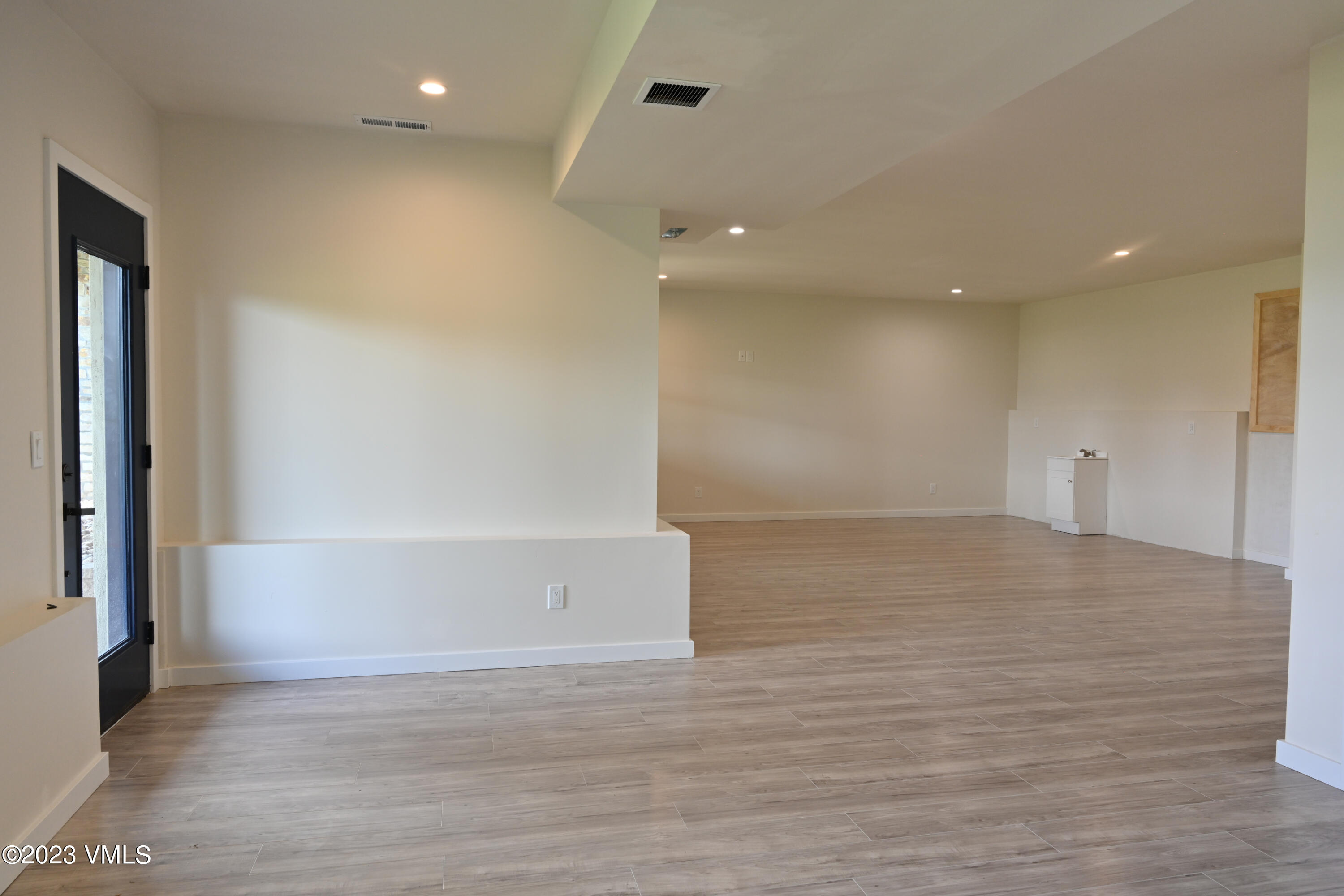 207 Aidan Road Eagle, CO 81631 - Photo 17 of 26 an empty room with wooden floor and windows