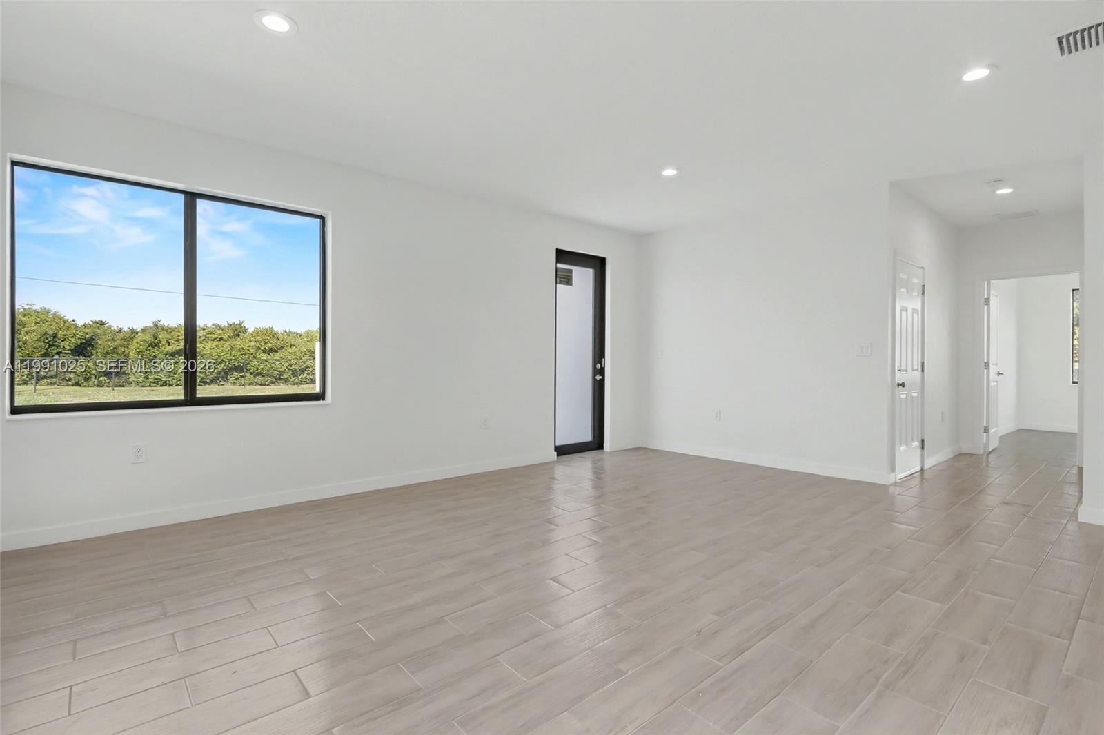 6140 Southwest 39th Street Miramar, FL 33023 - Photo 12 of 40 an empty room with wooden floor and windows