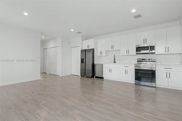 a view of kitchen with wooden floor and electronic appliances