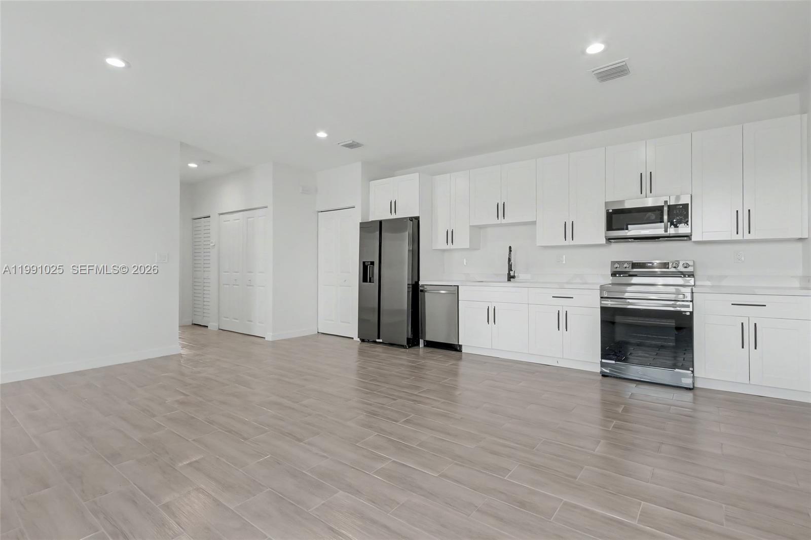 6140 Southwest 39th Street Miramar, FL 33023 - Photo 14 of 40 a view of kitchen with wooden floor and electronic appliances