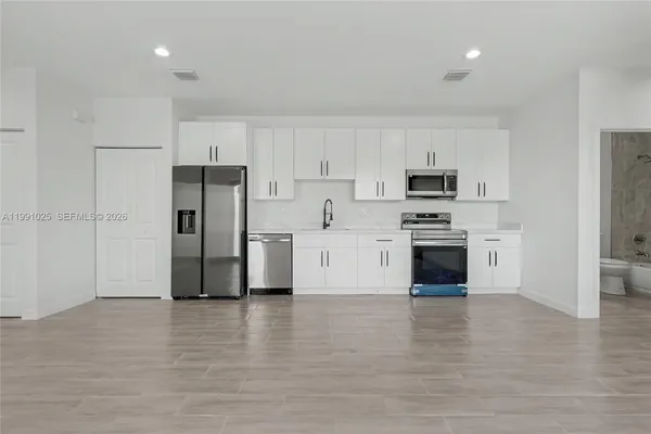 a kitchen with stainless steel appliances a refrigerator and a stove top oven