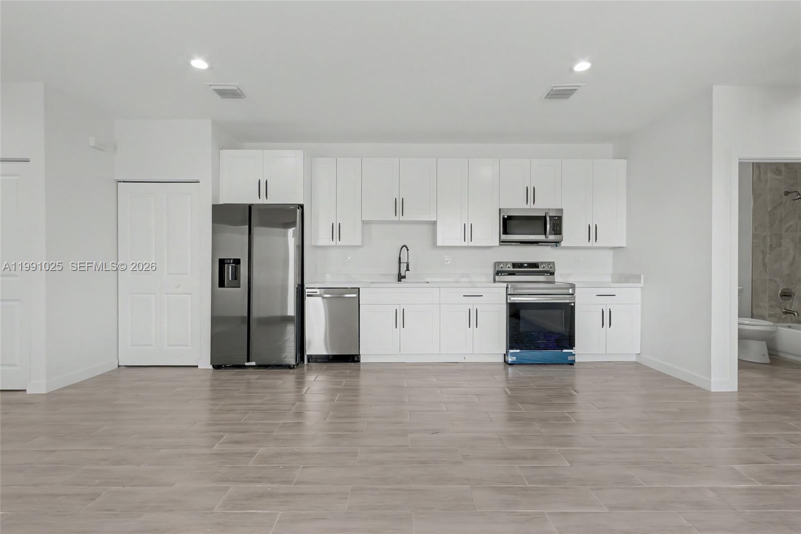 6140 Southwest 39th Street Miramar, FL 33023 - Photo 15 of 40 a kitchen with stainless steel appliances a refrigerator and a stove top oven