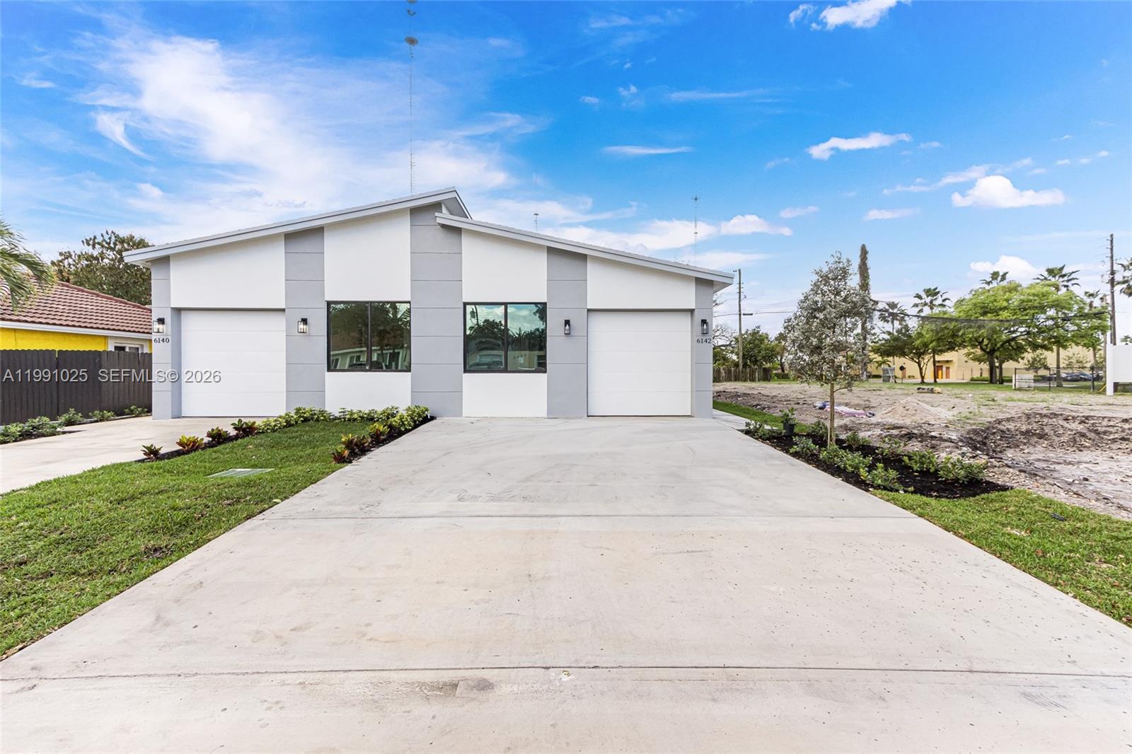 6140 Southwest 39th Street Miramar, FL 33023 - Photo 2 of 40 a front view of a house with a yard and garage
