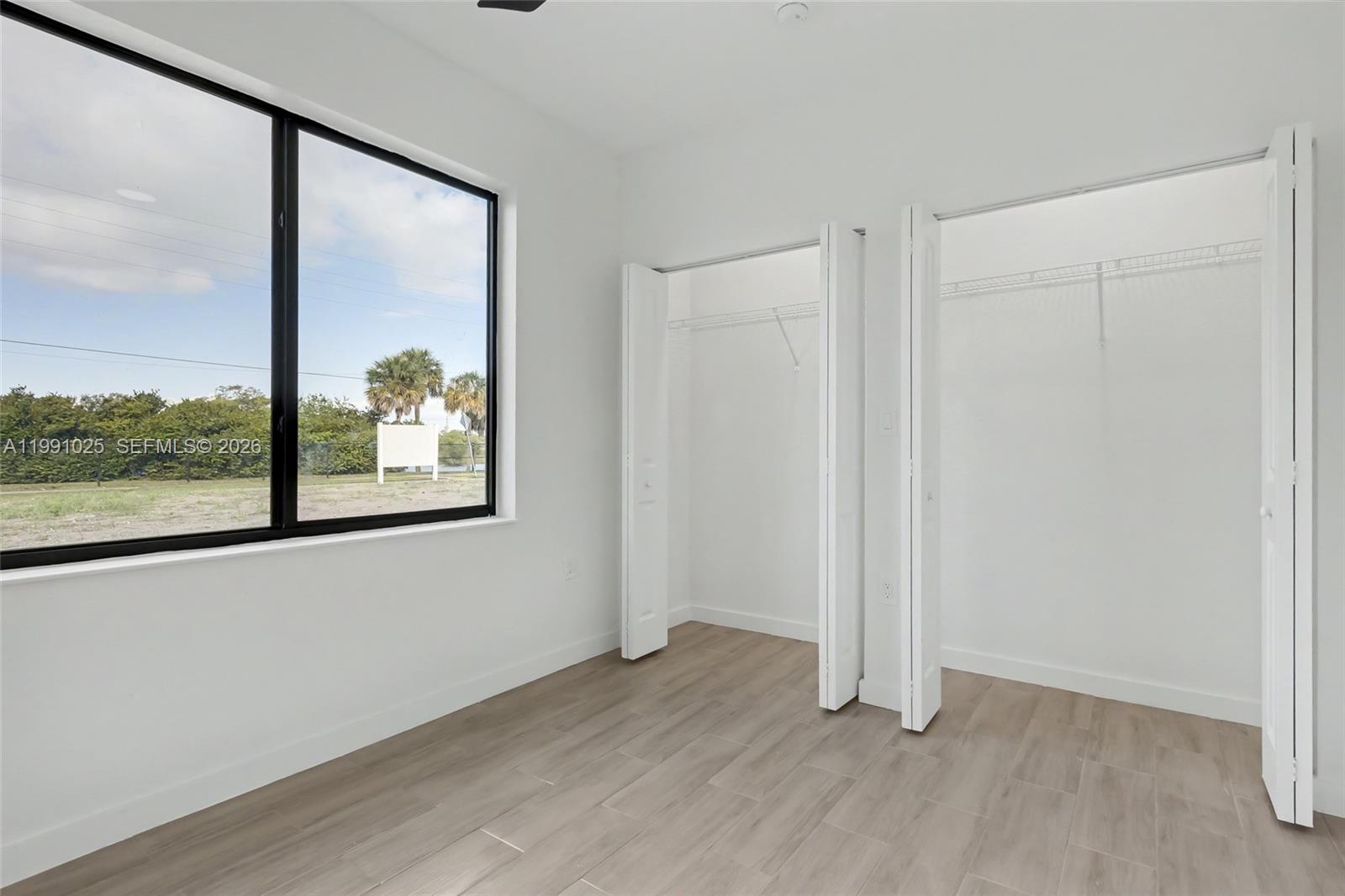 6140 Southwest 39th Street Miramar, FL 33023 - Photo 21 of 40 an empty room with wooden floor and windows
