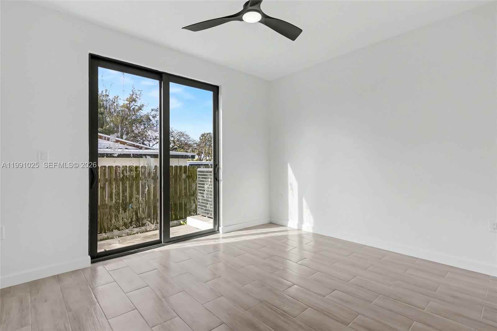 6140 Southwest 39th Street Miramar, FL 33023 - Photo 23 of 40 an empty room with wooden floor and windows