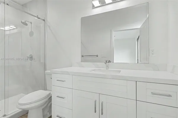 a bathroom with a shower a toilet and sink