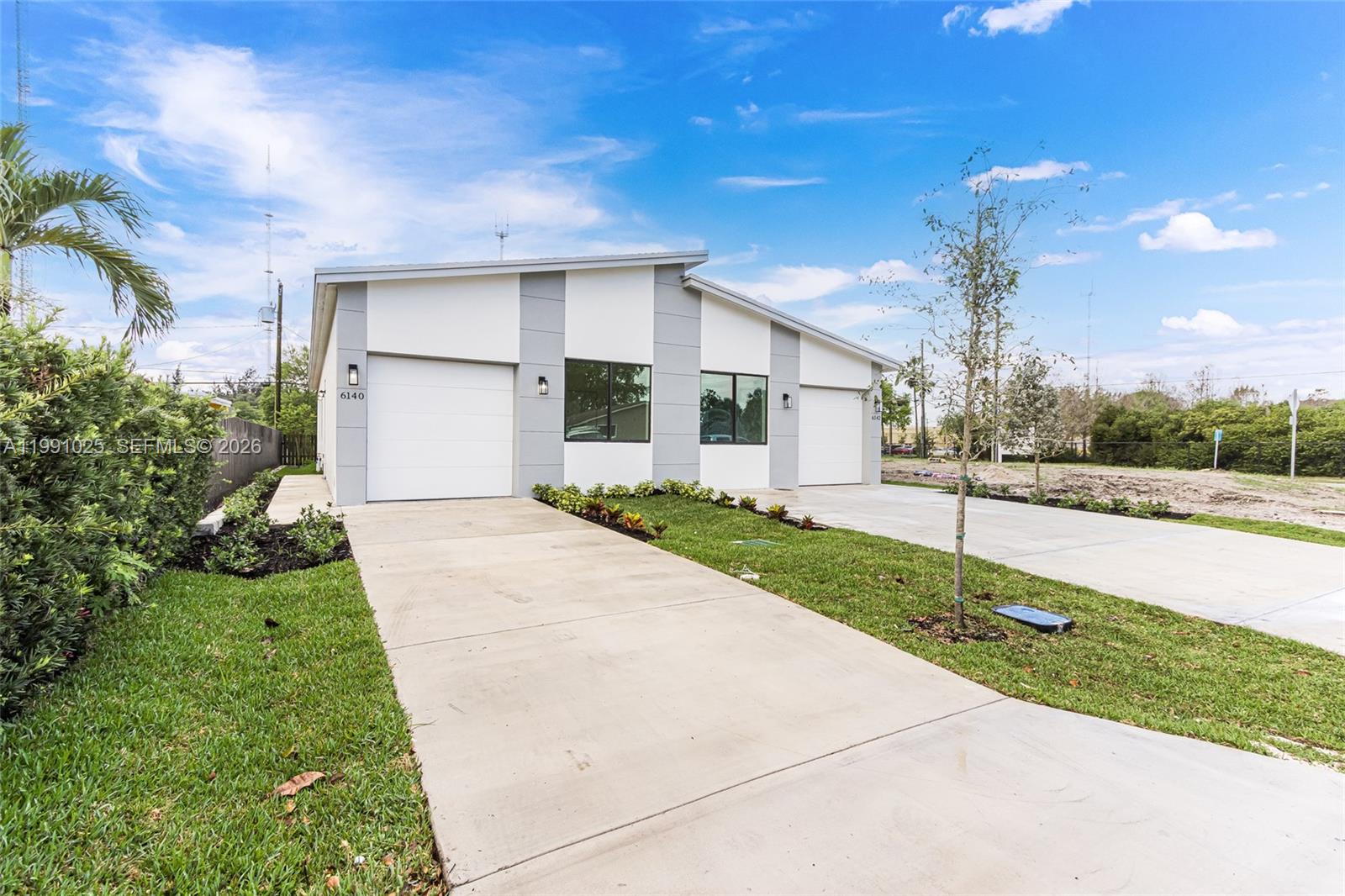 6140 Southwest 39th Street Miramar, FL 33023 - Photo 5 of 40 a front view of a house with a yard and garage