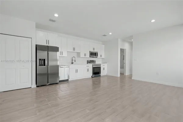 a kitchen with stainless steel appliances a refrigerator and a stove top oven