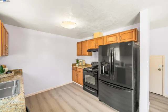 a kitchen with stainless steel appliances granite countertop a refrigerator and a stove top oven