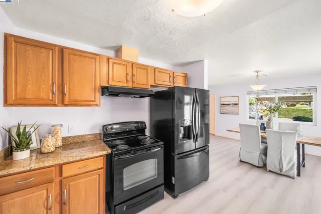 a kitchen with stainless steel appliances granite countertop a refrigerator stove and sink