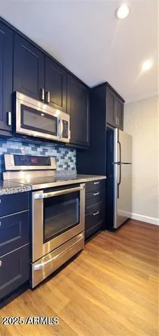 a kitchen with stainless steel appliances granite countertop a stove a refrigerator and a sink