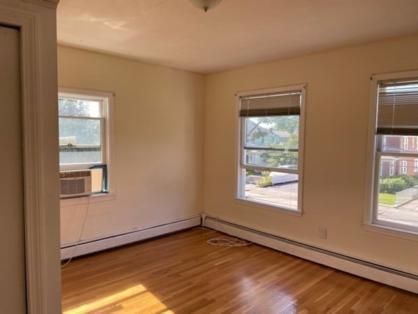 272-2 Nevada Street, Unit 2 Newton, MA 02460 - Photo 13 of 28 a view of an empty room with wooden floor and a window