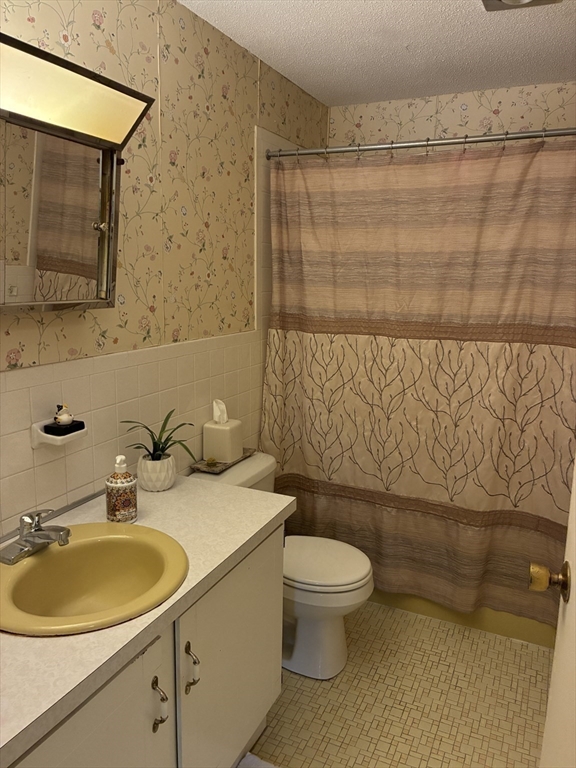 1 Summit Drive, Unit 57 Reading, MA 01867 - Photo 13 of 18 a bathroom with a sink a toilet and a mirror