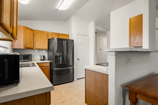 a kitchen with stainless steel appliances granite countertop a refrigerator and a stove