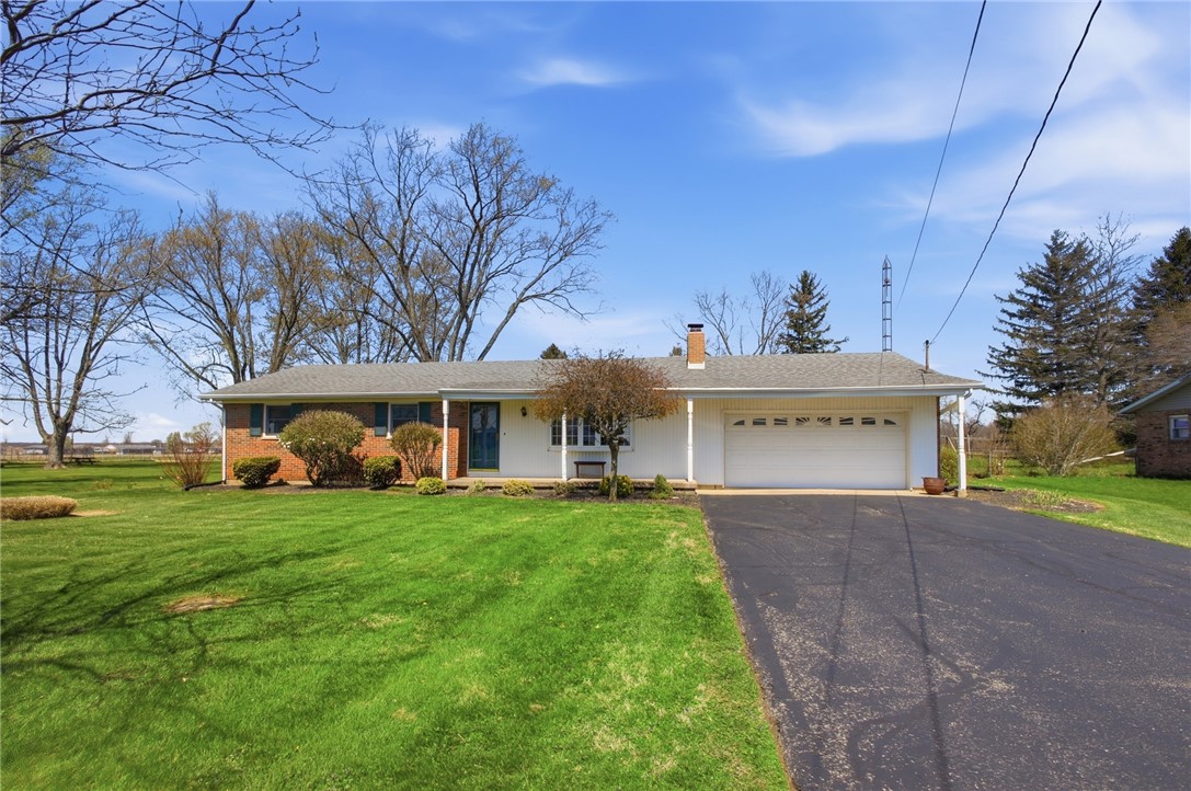 6718 Old Columbus Road South Vienna, OH 45369 - Photo 2 of 33 This ranch-style home features a spacious front yard and a paved driveway leading to an attached garage.
