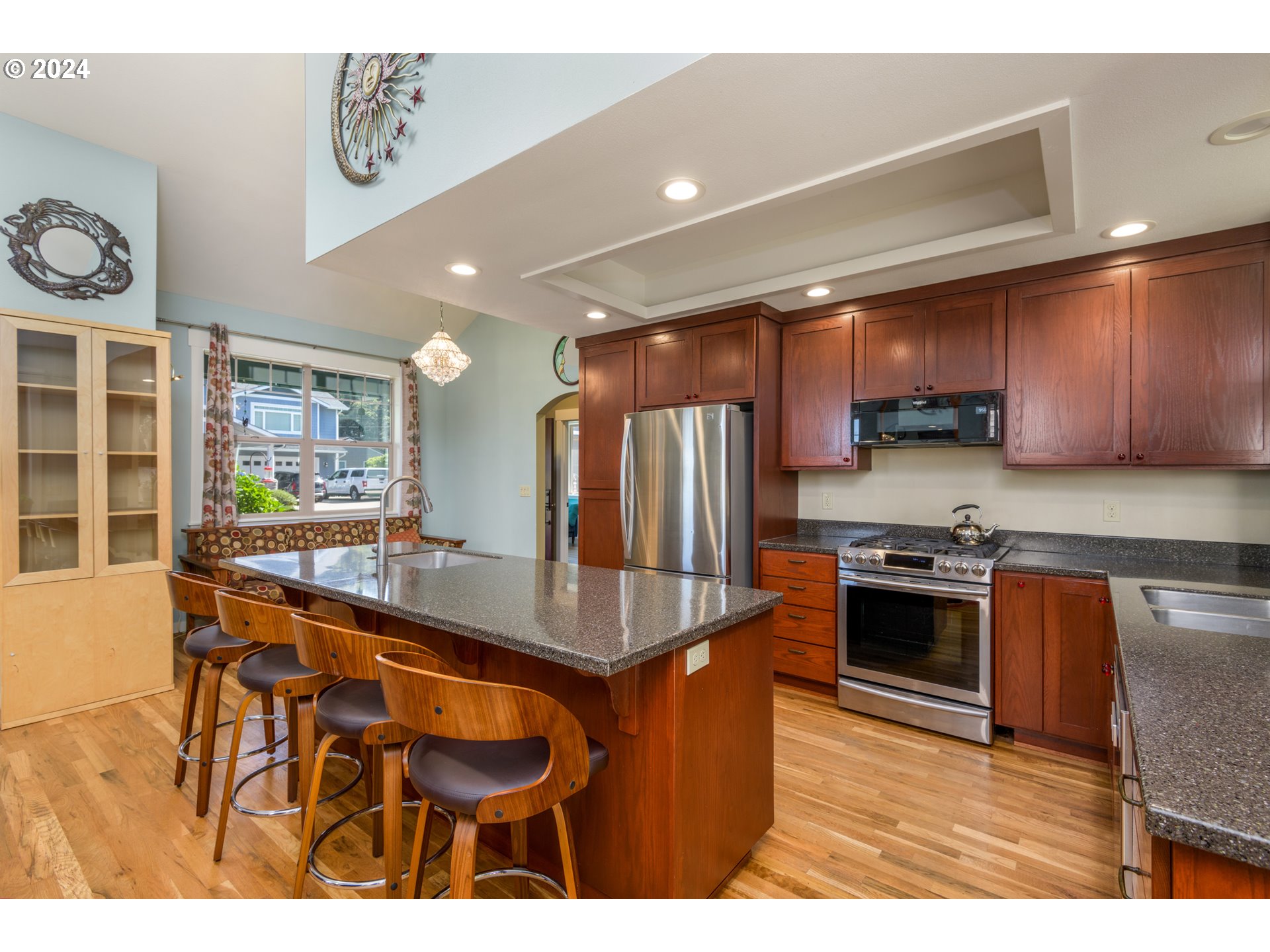 490 Lemwick Lane Yachats, OR 97498 - Photo 11 of 42 a kitchen with stainless steel appliances kitchen island granite countertop a table chairs and a refrigerator