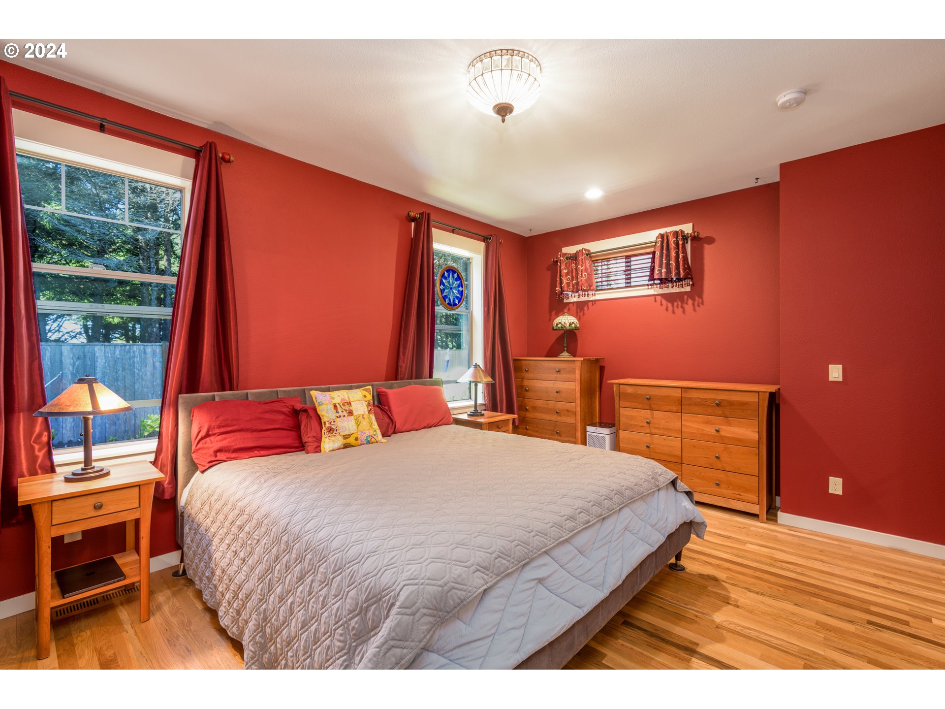 490 Lemwick Lane Yachats, OR 97498 - Photo 22 of 42 a bedroom with a large bed and a flat tv screen on dresser