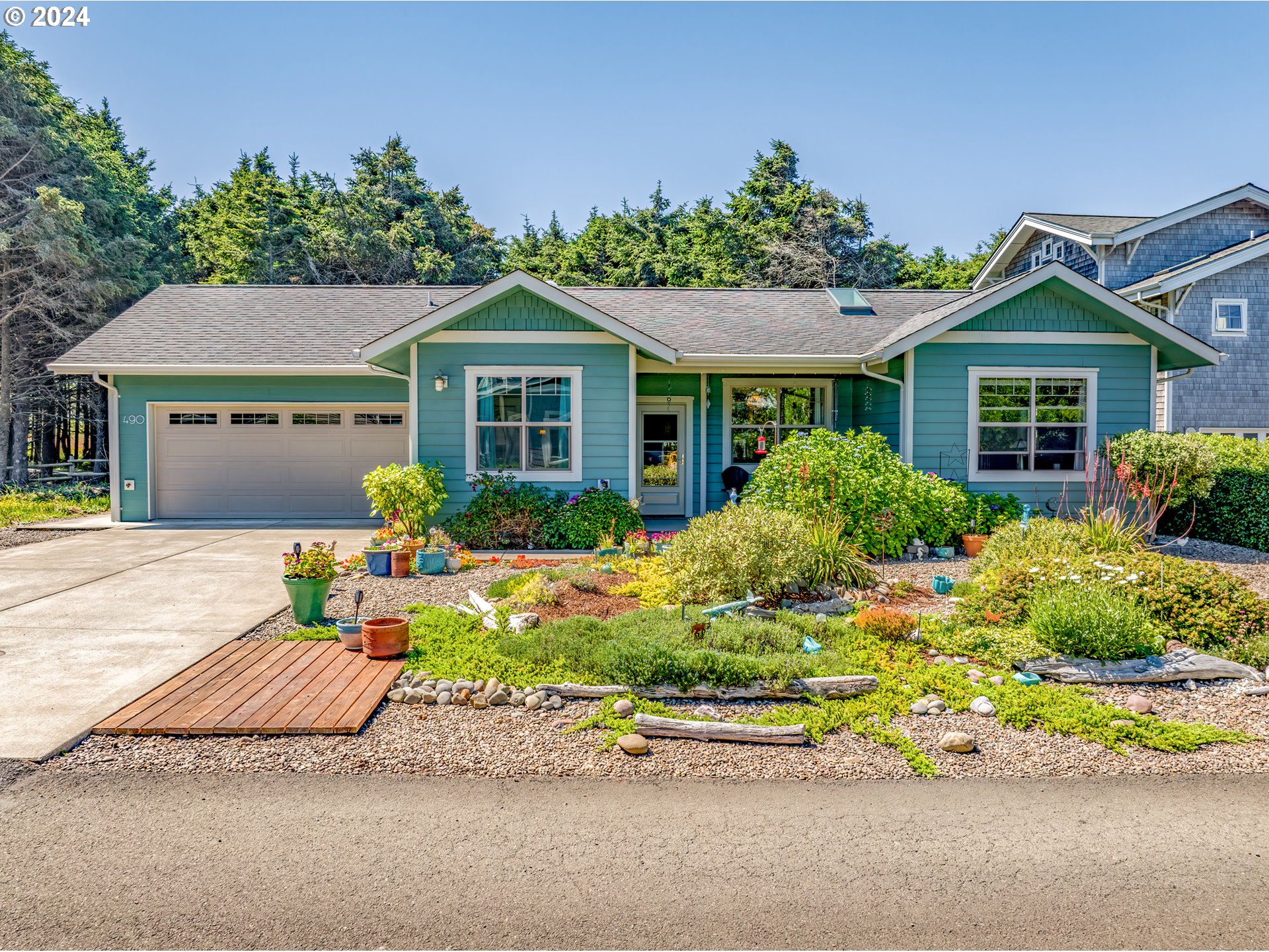 490 Lemwick Lane Yachats, OR 97498 - Photo 3 of 42 a front view of a house with a yard and potted plants
