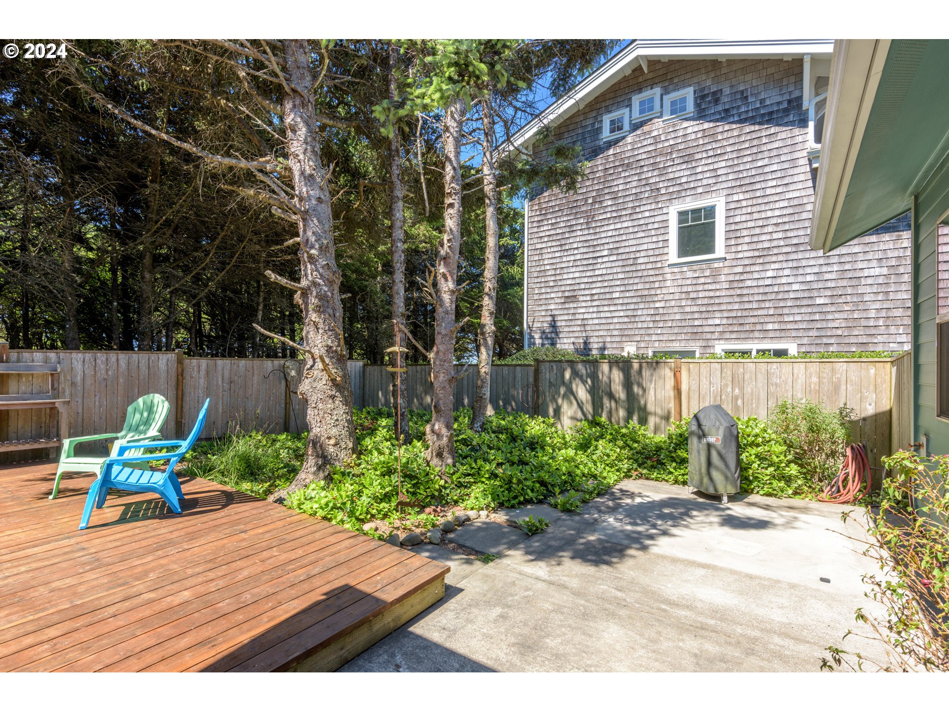 490 Lemwick Lane Yachats, OR 97498 - Photo 34 of 42 a backyard of a house with table and chairs