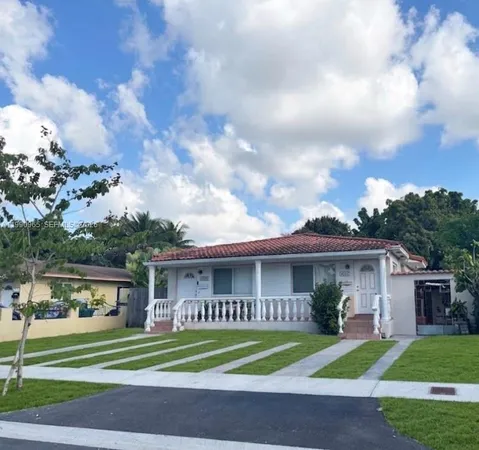 a view of a big house in a big yard with large trees